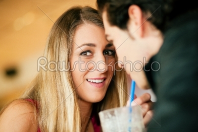Couple in restaurant drinking milkshake