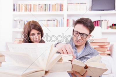 couple studying together at home with lot of books