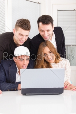 curious friends looking at laptop computer monitor together