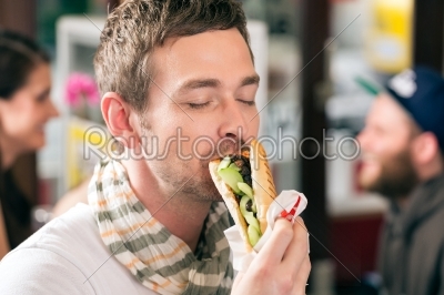 Customer eating Hotdog in fast food snack bar