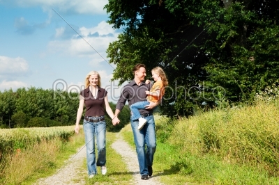 Family having a walk carrying child