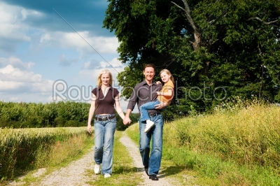 Family having a walk carrying child