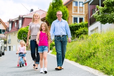 Family having walk in front of homes in village