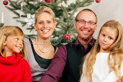 Family in front of Christmas tree