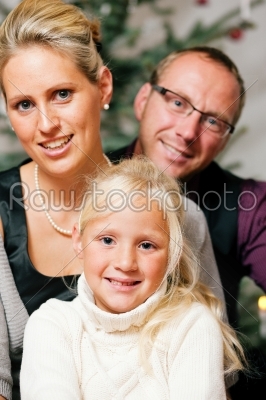 Family in front of Christmas tree