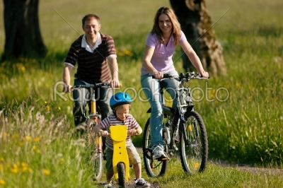 Family riding bicycles in summer