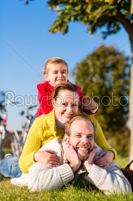 Family with bicycle in park  in fall