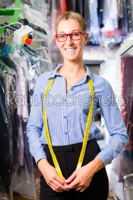 Female cleaner in laundry shop or dry-cleaning 