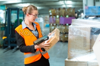 Female worker scans package in warehouse of forwarding