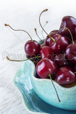 fresh red cherries on a blue plate