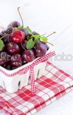 fresh red cherries on a white bowl