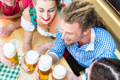friends drinking beer in Bavarian restaurant or pub