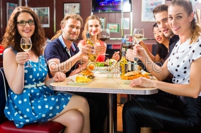 Friends eating and drinking in fast food diner