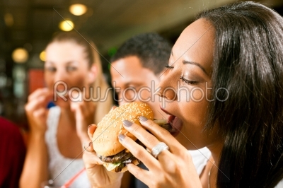 Friends eating fast food in a restaurant