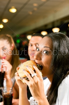 Friends eating fast food in a restaurant