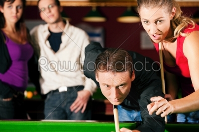 Friends playing billiards together