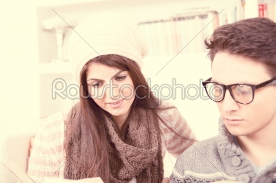 girl and boy with glasses reading together