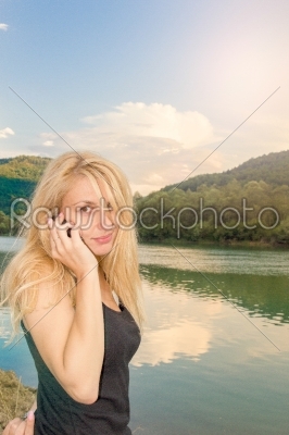 girl at the lake talking on the phone