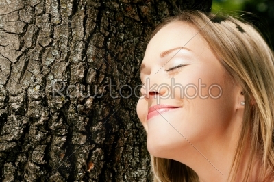 Girl cuddling a tree and dreaming