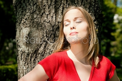 Girl dreaming on a tree in a park