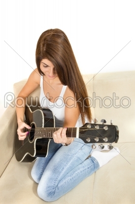 girl playing guitar on the couch