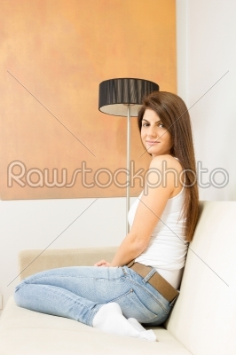 girl sitting on sofa next to lamp