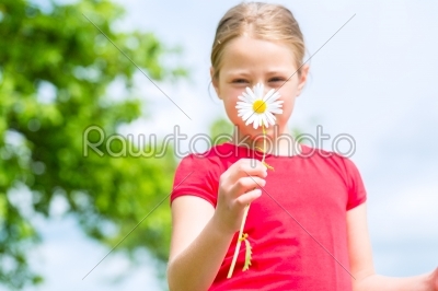 Girl with buttercups in summer outdoors