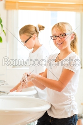 Girls are washing hands in the bath
