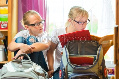 Girls doing homework and packing school bags