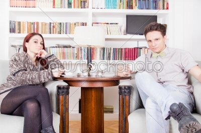 glamor couple sitting on armchairs in the library