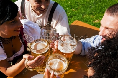 Group of four friends in beer garden eating and drinking