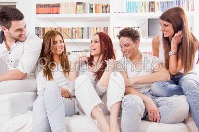 group of friends sitting on sofa talking and smiling