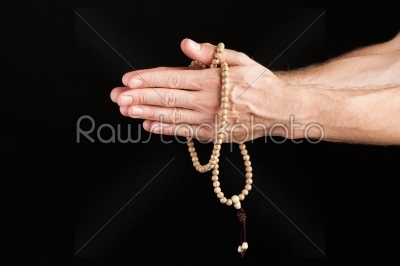 Hand praying with chain 