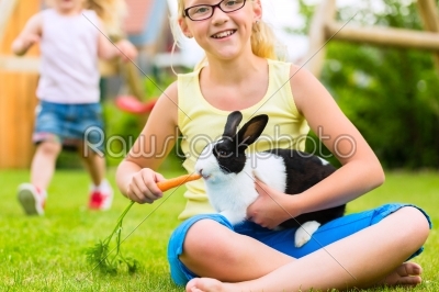 Happy child with bunny pet at home in garden