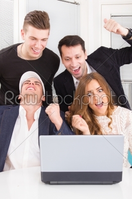 happy excited business people winning online looking at laptop c