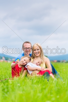 Happy Family outdoors sitting on grass