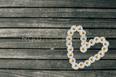 Heart made out of flowers on a wooden background