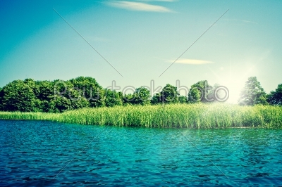 Idyllic lake with blue water and green trees