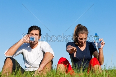 Jogger couple resting and drinking water