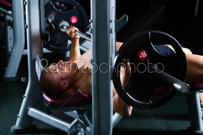 Man in gym or fitness studio on weight bench