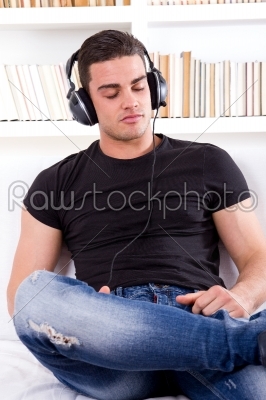 man relaxing in sofa with headphones on