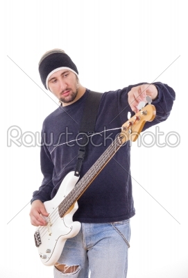 man tuning a guitar with adjustments