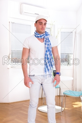 man with a scarf and white cap posing in the living room