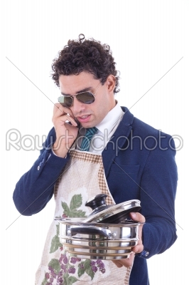 man with an apron holding a cooking pot and talking over phone
