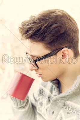 man with glasses drinking coffee outdoors