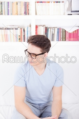 man with glasses sitting on a couch