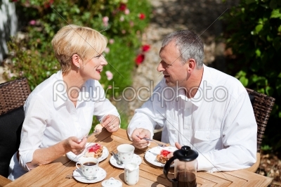Mature couple having coffee on porch