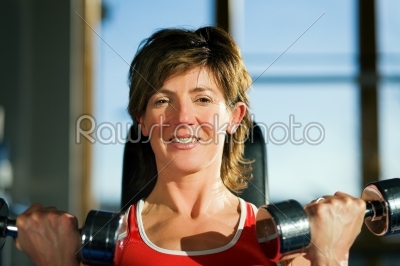 Mature woman lifting dumbbells