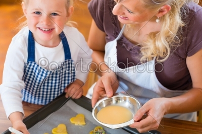 Mother and daughter baking cookies together