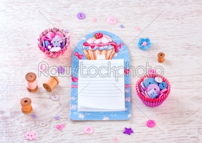 notebook with sewing items.  a check fabrics, buttons, thread and pins
